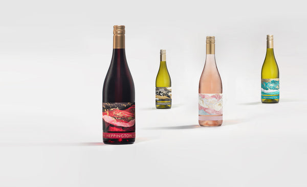 Four wine bottles of different types on a white background